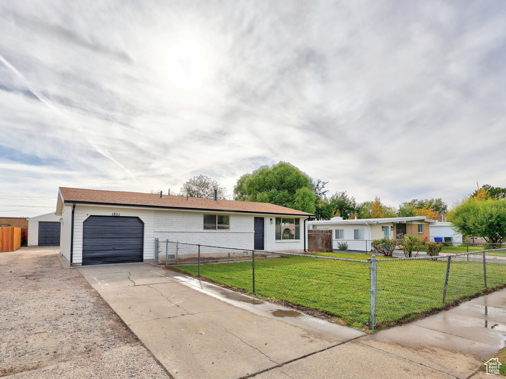 Ranch-style house featuring a front lawn and a garage