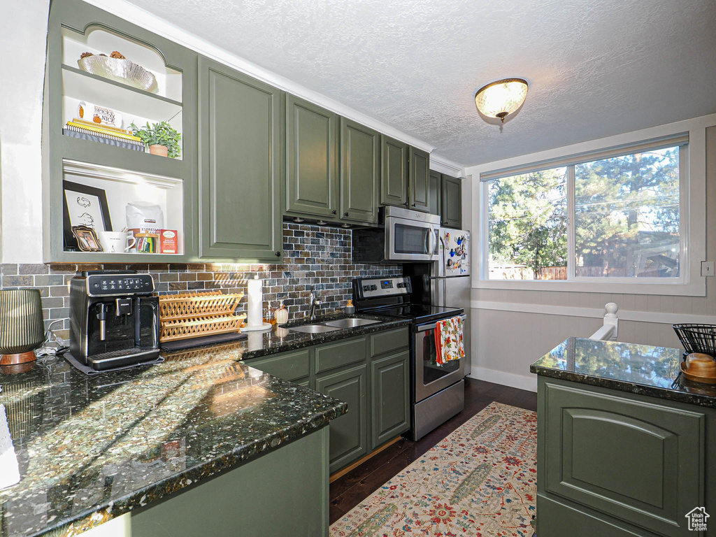 Kitchen featuring sink, stainless steel appliances, green cabinets, and dark hardwood / wood-style flooring