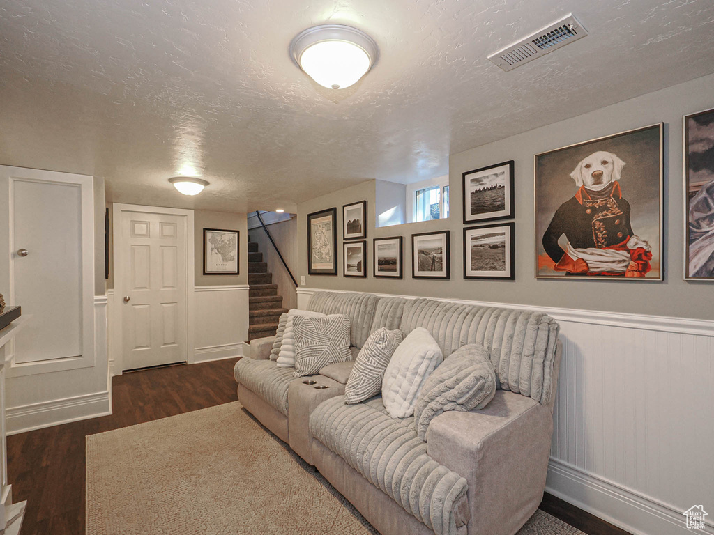 Living room featuring dark wood-type flooring and a textured ceiling