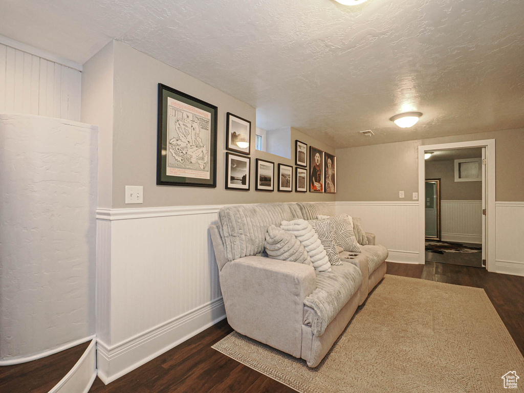 Living room featuring dark hardwood / wood-style floors and a textured ceiling