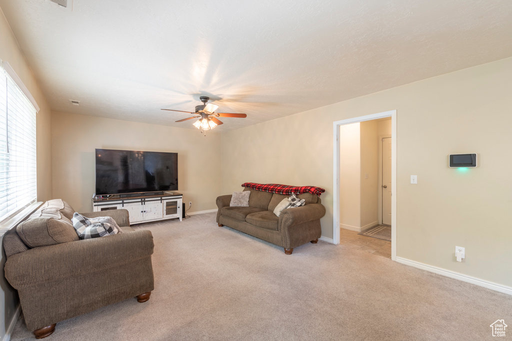 Living room with ceiling fan and light colored carpet