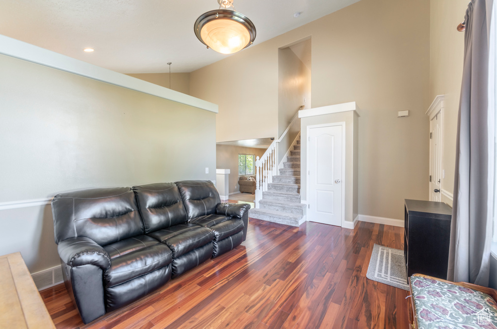 Living room featuring dark hardwood / wood-style floors and high vaulted ceiling