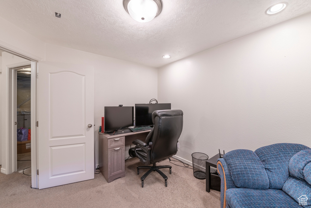 Carpeted office featuring a textured ceiling