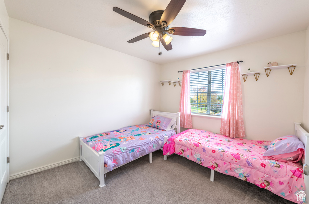 Carpeted bedroom featuring ceiling fan