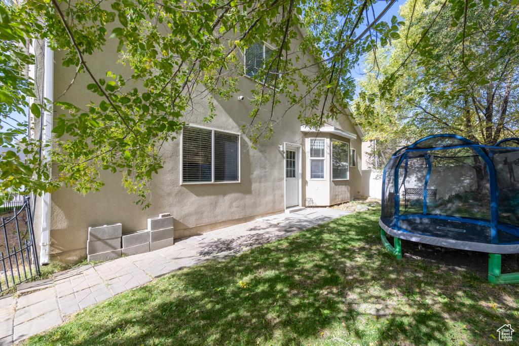 Exterior space with a trampoline and a patio area