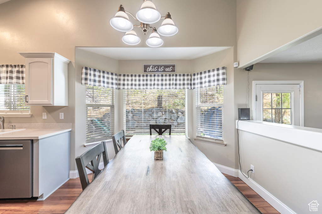 Dining area with hardwood / wood-style floors and a notable chandelier