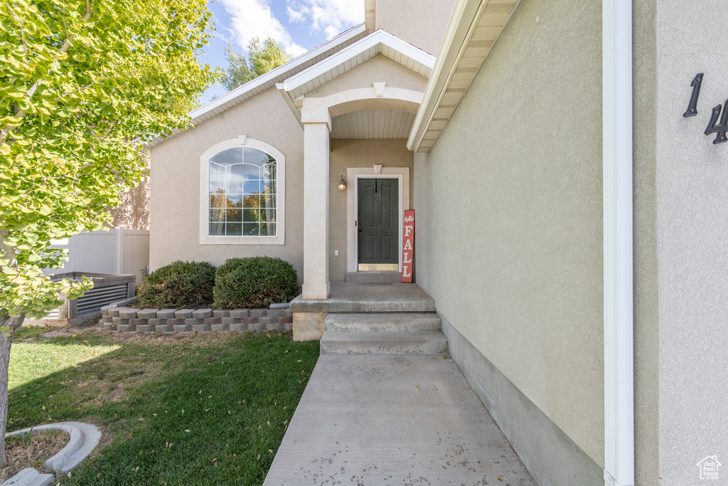 Doorway to property featuring a yard