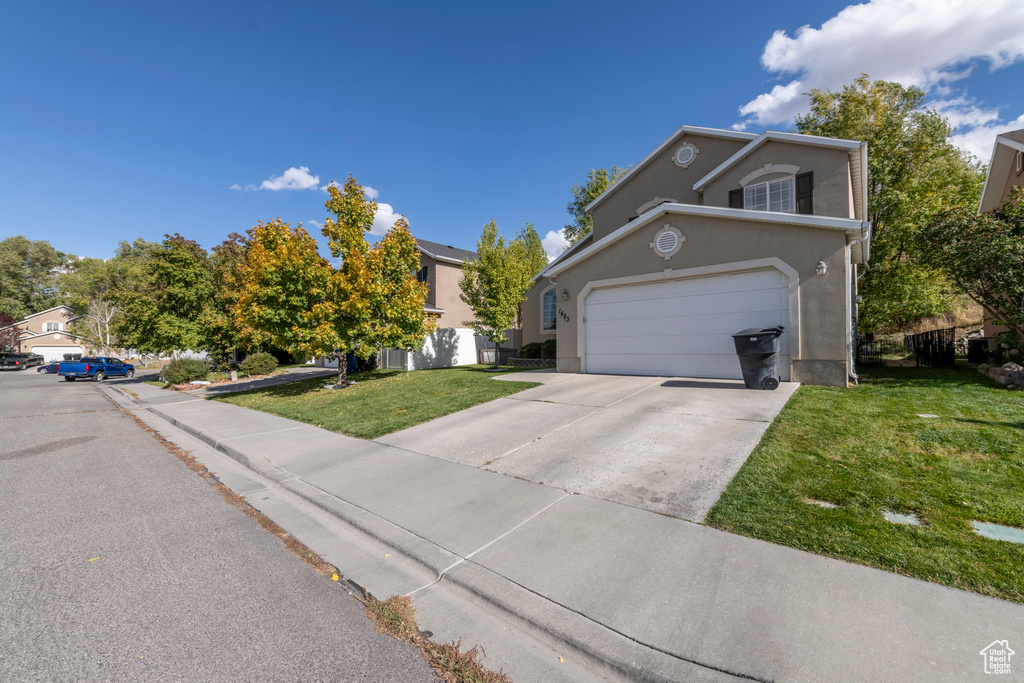 Front of property featuring a front lawn and a garage