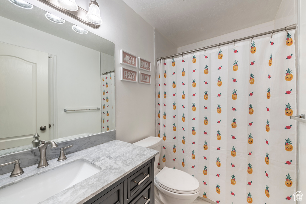 Bathroom with vanity, toilet, and a shower with curtain