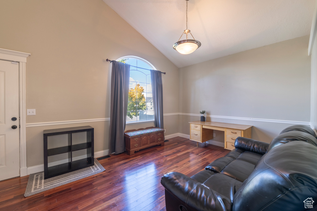 Living room featuring high vaulted ceiling and dark wood-type flooring