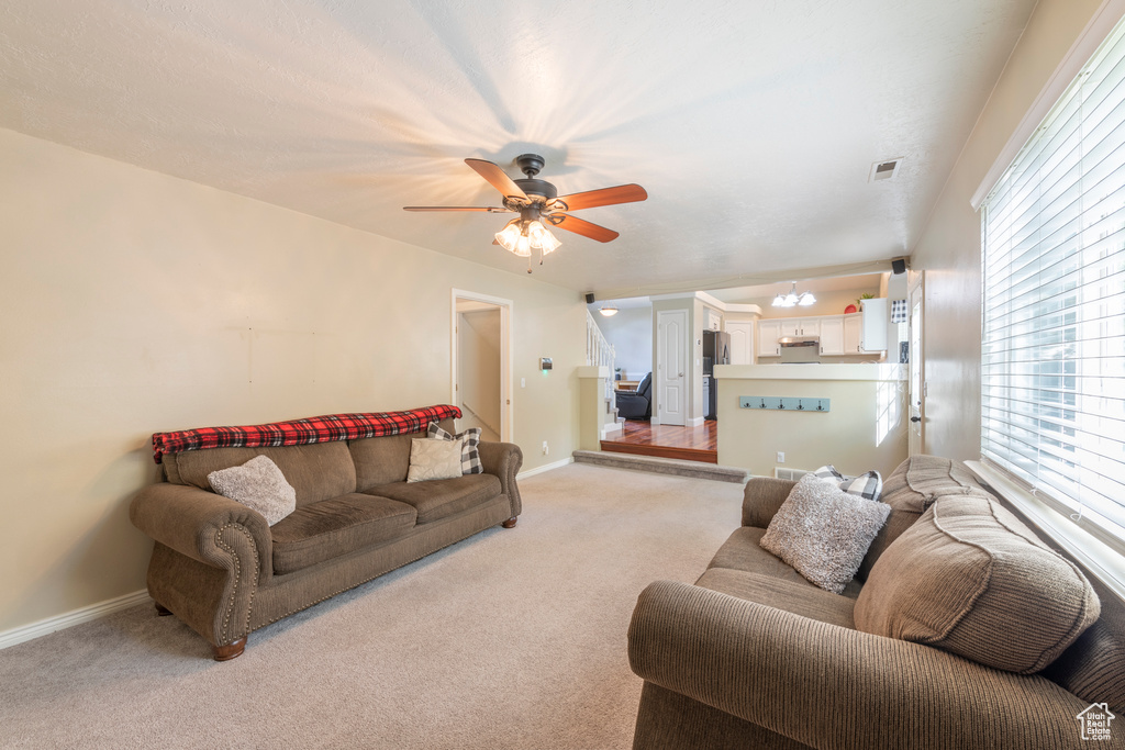 Carpeted living room with ceiling fan