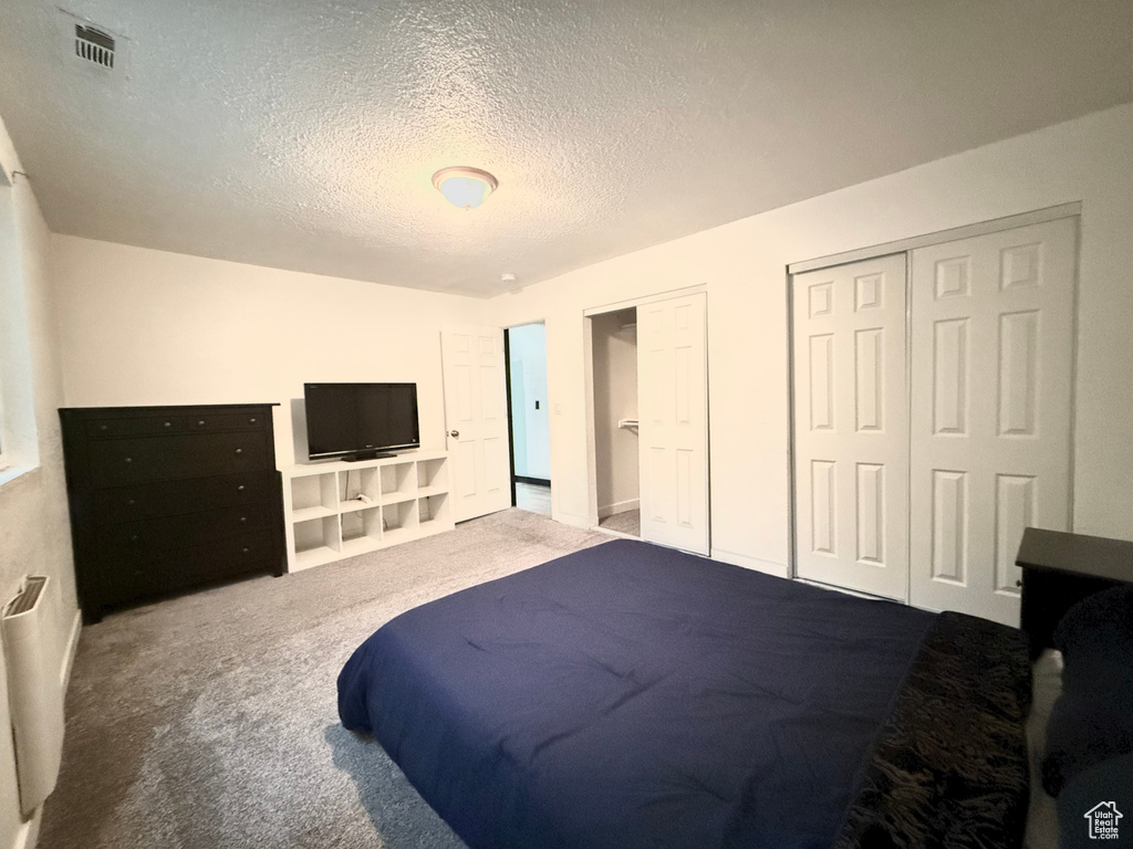 Bedroom featuring a textured ceiling and carpet flooring