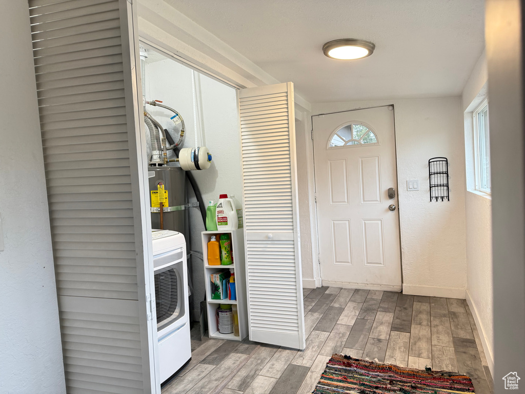 Laundry room featuring washer / dryer, light hardwood / wood-style flooring, and gas water heater