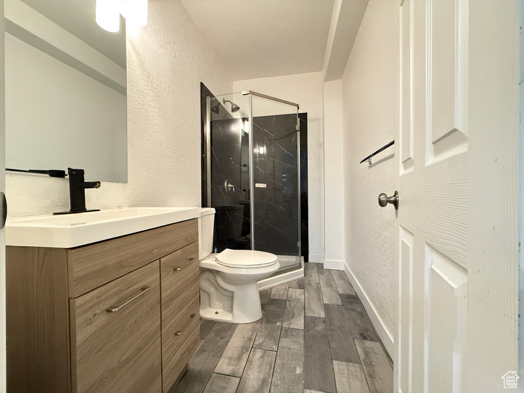 Bathroom featuring vanity, hardwood / wood-style floors, toilet, and walk in shower