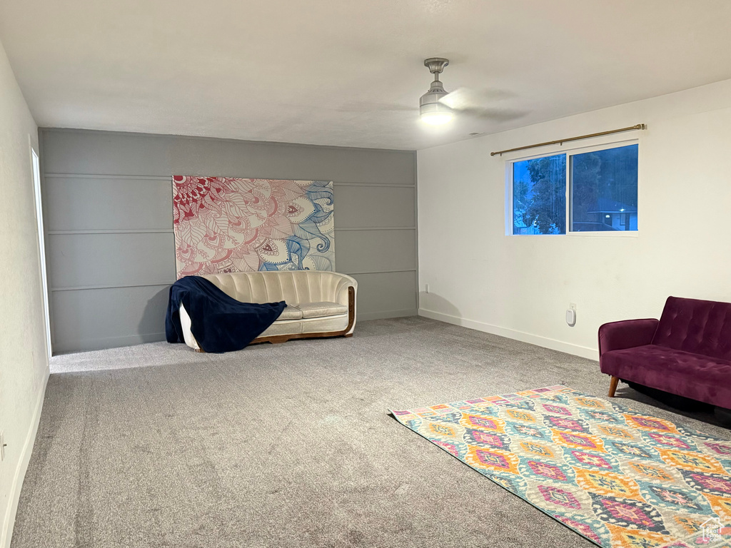 Living area featuring ceiling fan and carpet