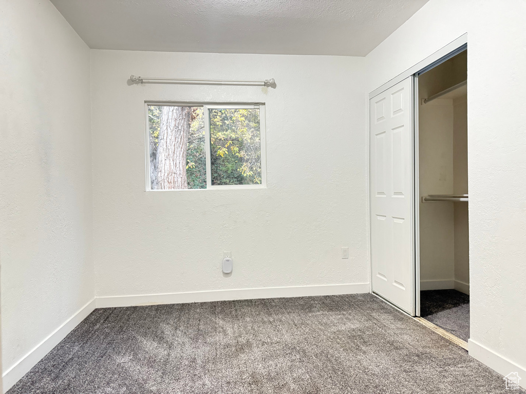 Unfurnished bedroom with a closet and carpet