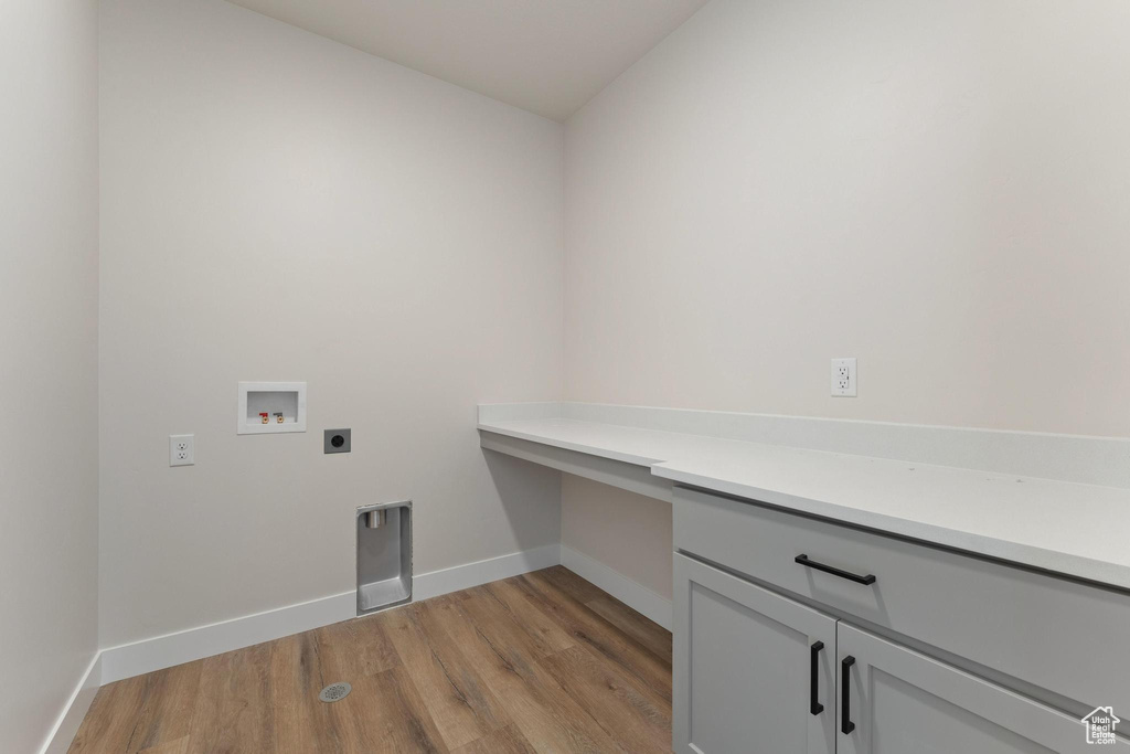 Laundry room featuring hookup for a washing machine, cabinets, light hardwood / wood-style flooring, and hookup for an electric dryer