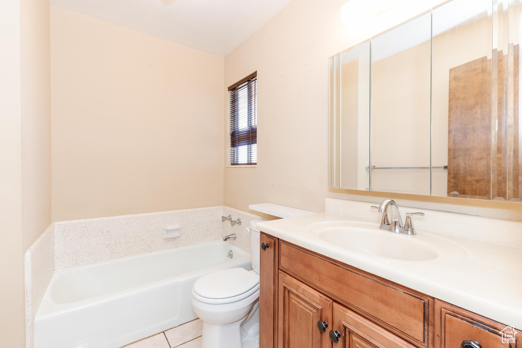 Bathroom with vanity, toilet, a tub, and tile patterned flooring