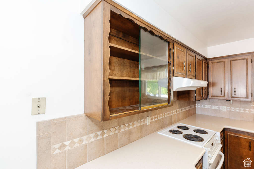 Kitchen with decorative backsplash and white range with electric cooktop