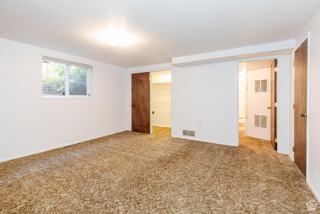 Unfurnished bedroom featuring a closet, carpet floors, and a walk in closet