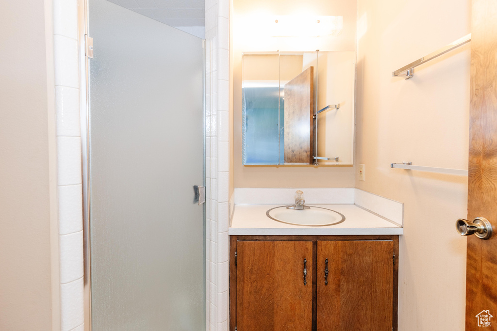 Bathroom featuring vanity and a shower with shower door