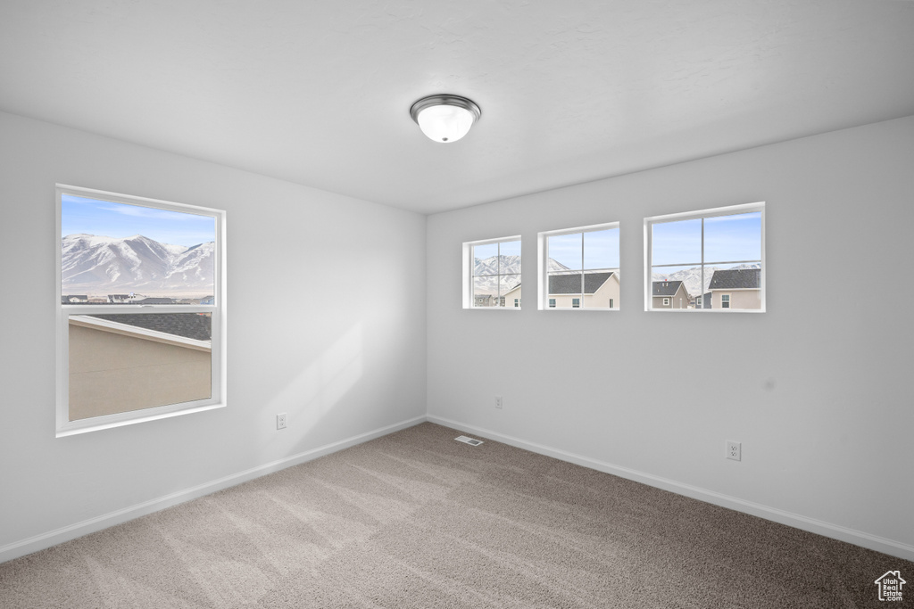 Spare room featuring carpet floors and baseboards