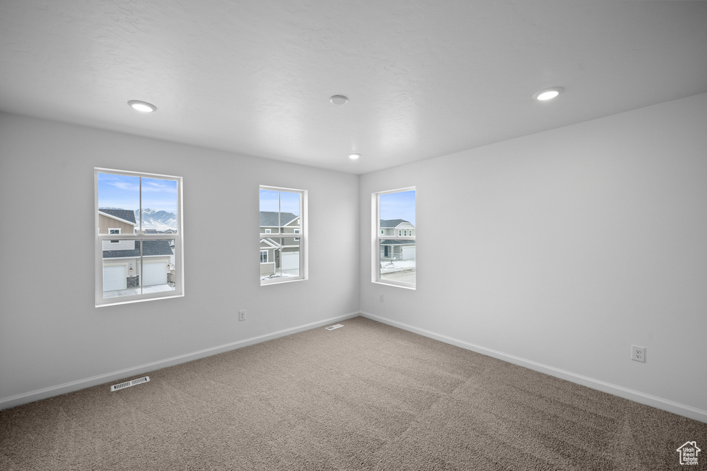 Carpeted empty room featuring baseboards and recessed lighting