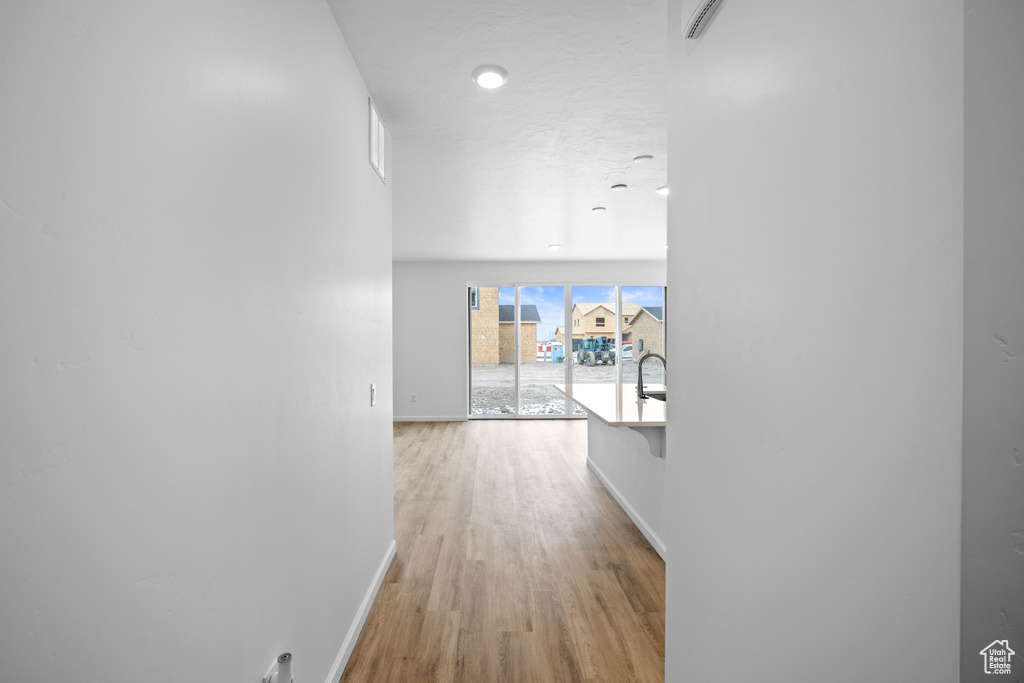 Hallway featuring baseboards and light wood finished floors