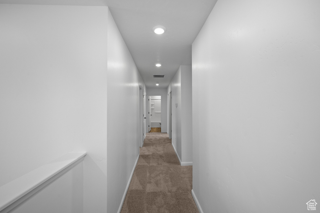 Hall featuring light colored carpet, baseboards, and recessed lighting