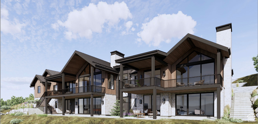 Back of property with a chimney, stone siding, stairs, and a balcony