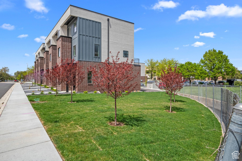 View of home\'s community featuring a lawn and fence
