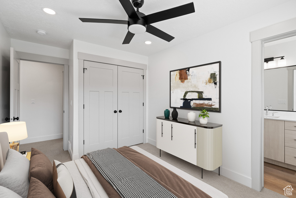 Bedroom with baseboards, a closet, light carpet, recessed lighting, and ensuite bathroom