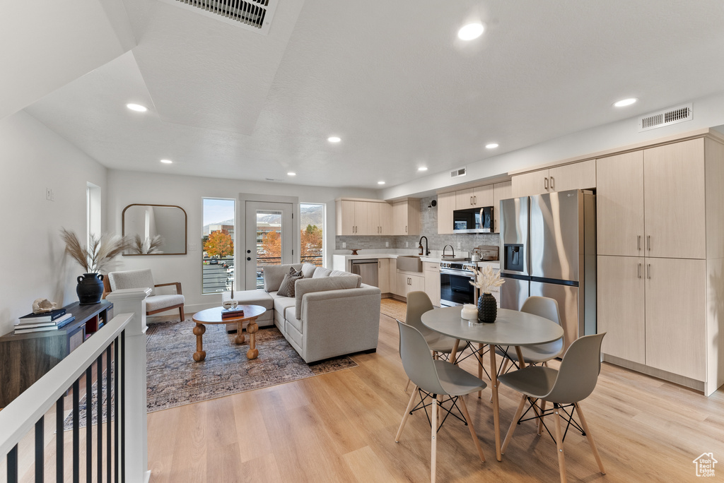 Living area featuring light wood finished floors and recessed lighting