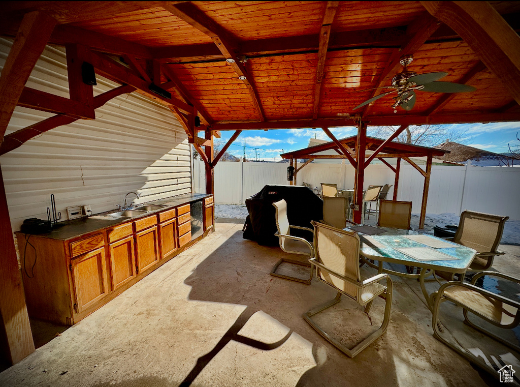 View of patio with wine cooler, a wet bar, a gazebo, area for grilling, and ceiling fan