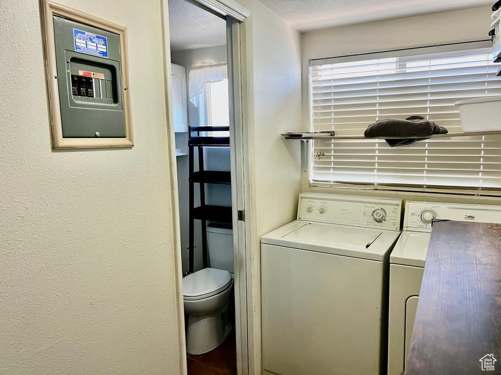 Laundry area featuring a textured ceiling and washing machine and clothes dryer