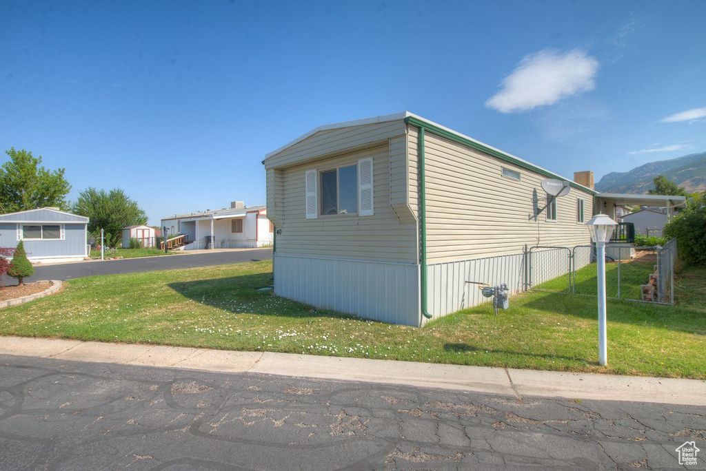 View of side of property featuring a mountain view and a lawn