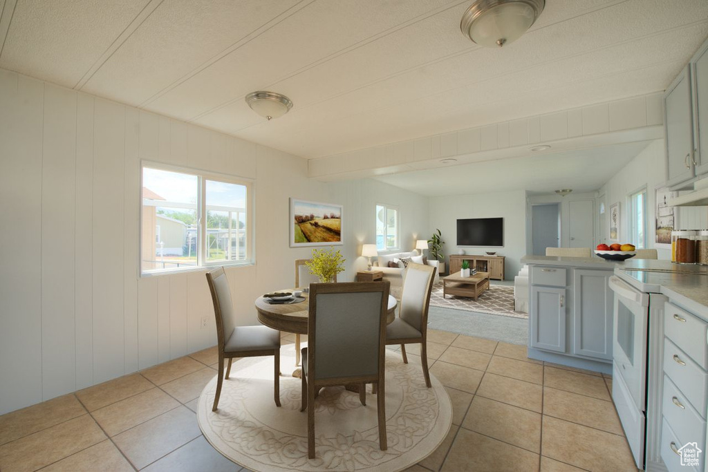 Dining room featuring wooden walls and light tile patterned floors