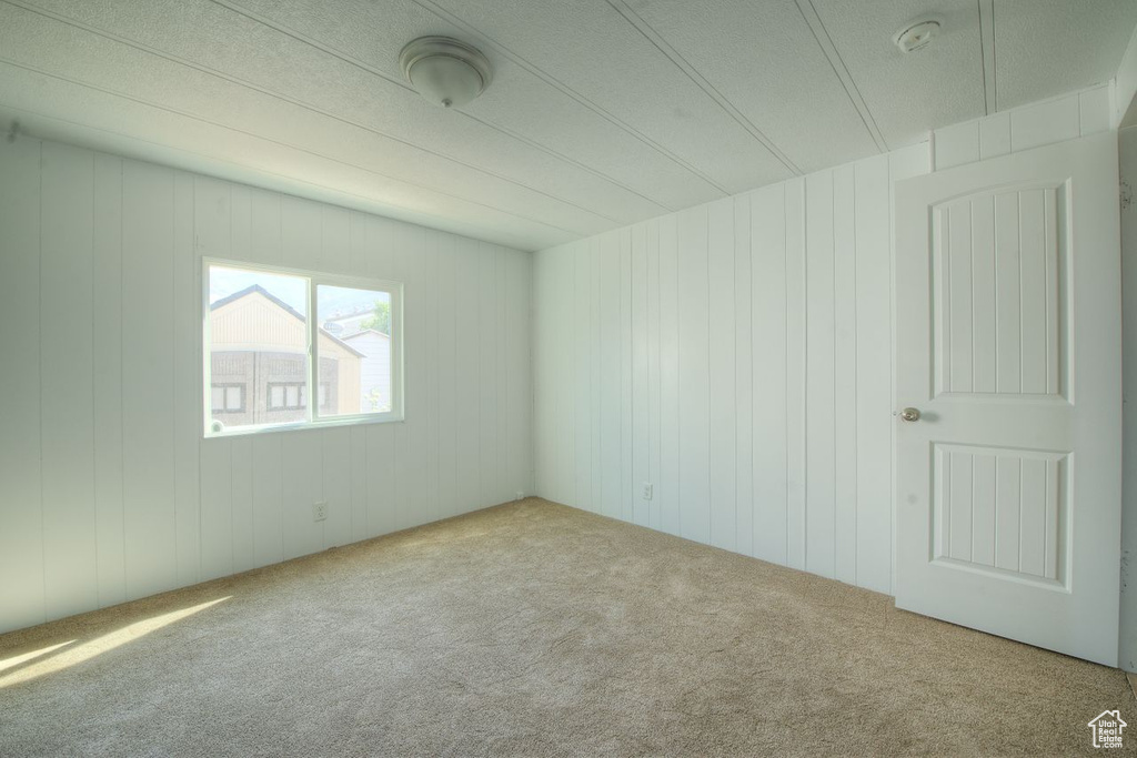 Carpeted empty room with wooden walls