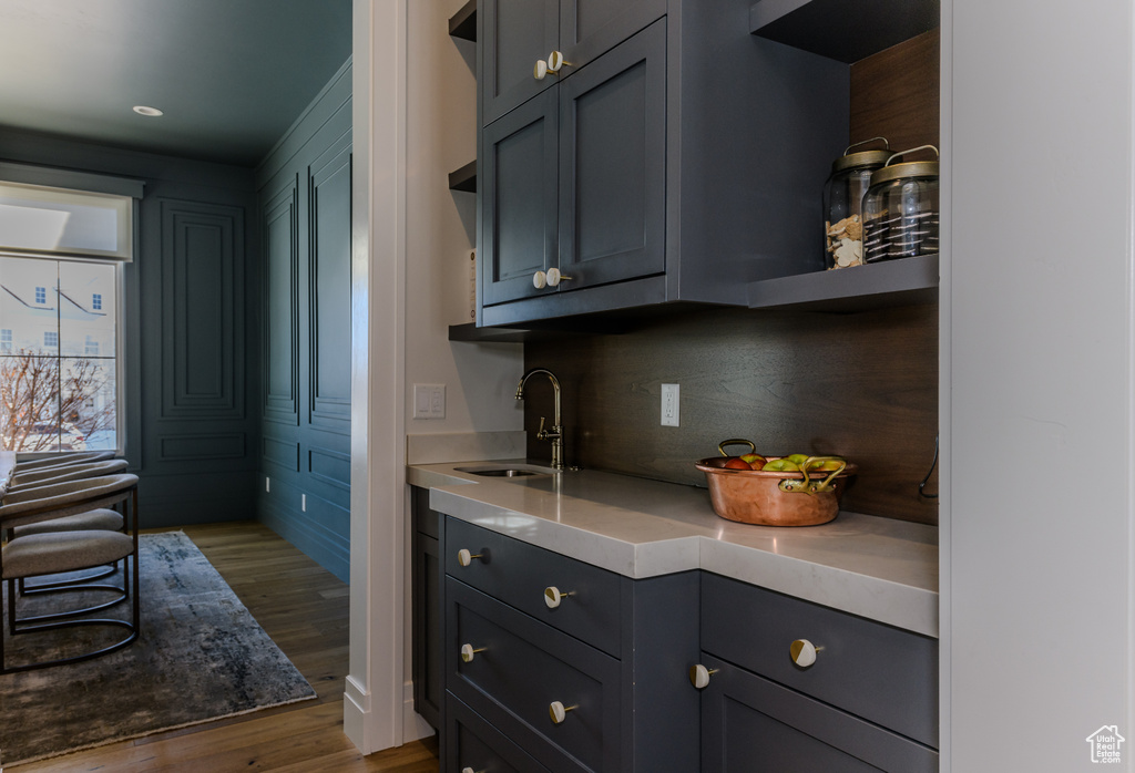 Kitchen featuring sink, light hardwood / wood-style floors, and tasteful backsplash