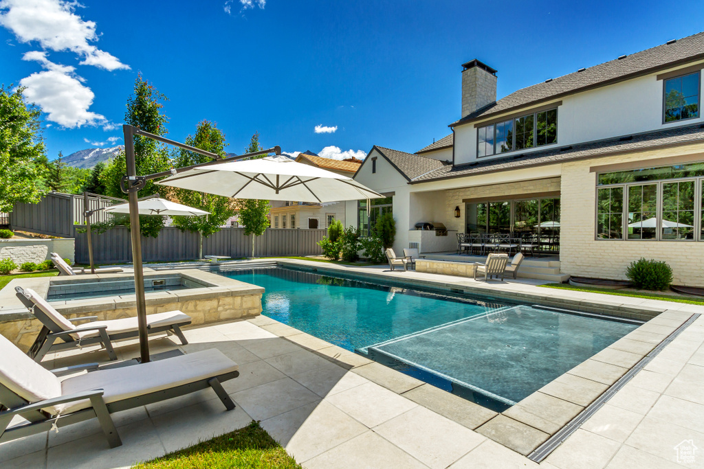 View of swimming pool featuring an in ground hot tub and a patio area