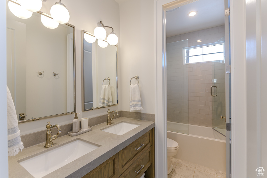 Full bathroom featuring vanity, toilet, and shower / bath combination with glass door