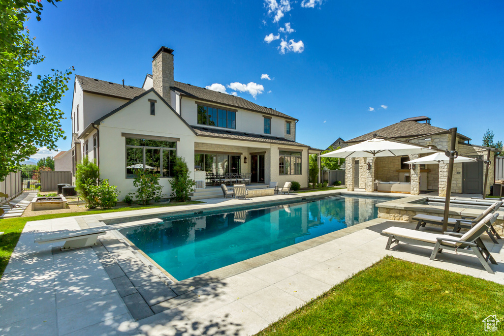 Back of property with a patio and a fenced in pool