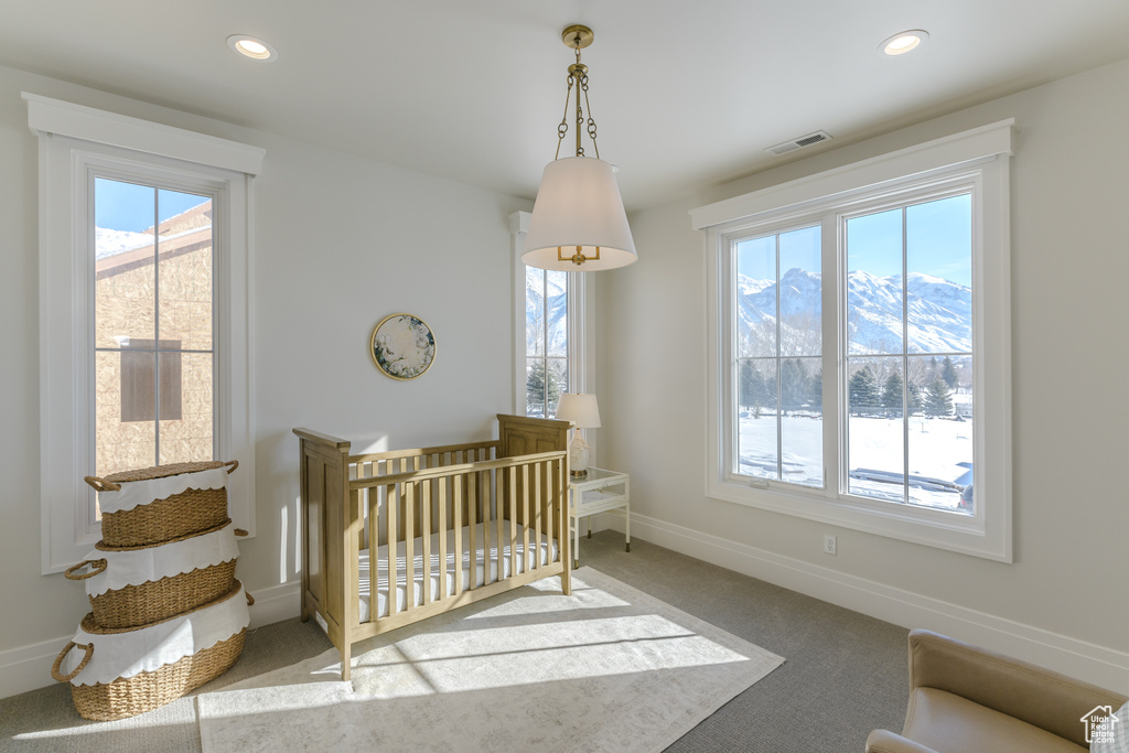 Bedroom with a nursery area, a mountain view, and carpet flooring