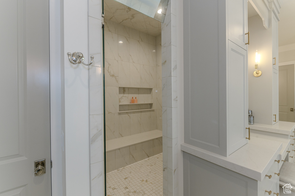 Bathroom featuring a tile shower and vanity