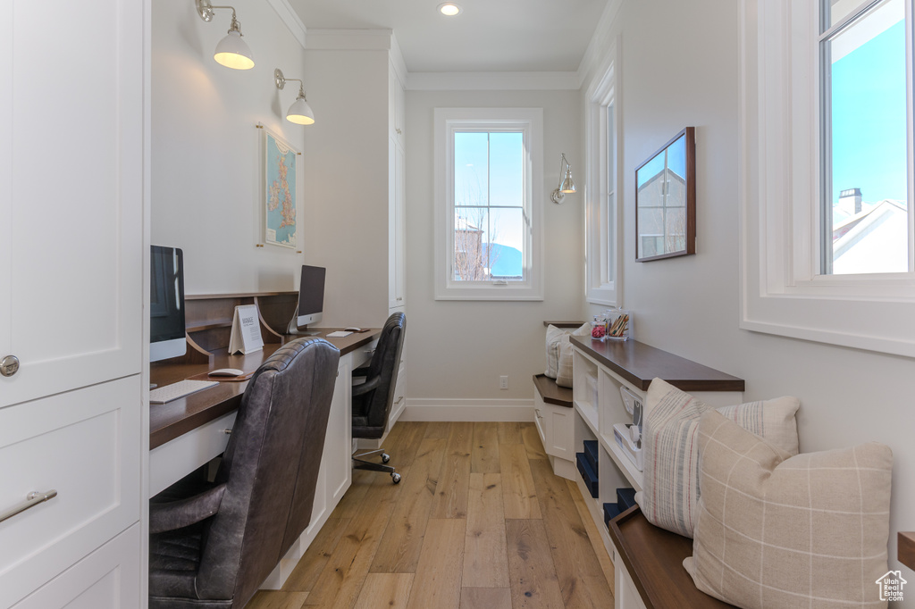 Office space with ornamental molding and light wood-type flooring