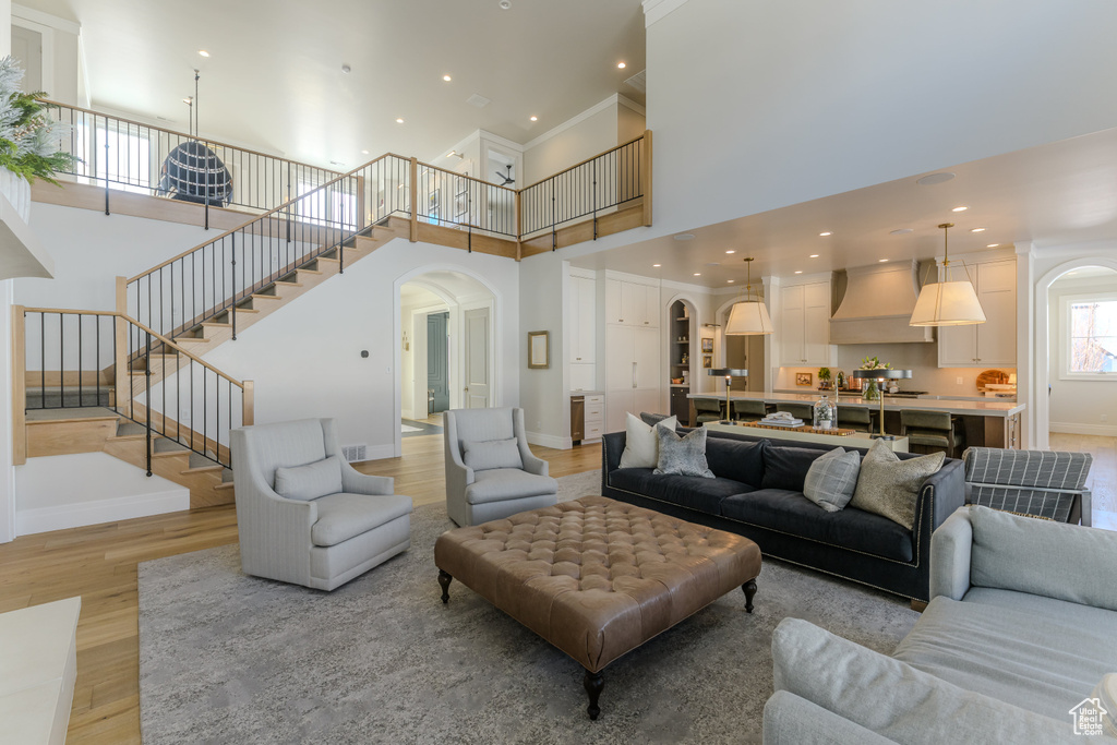 Living room with a high ceiling and light hardwood / wood-style flooring