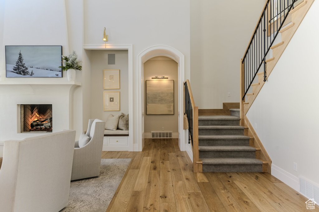 Interior space featuring a towering ceiling and light hardwood / wood-style flooring