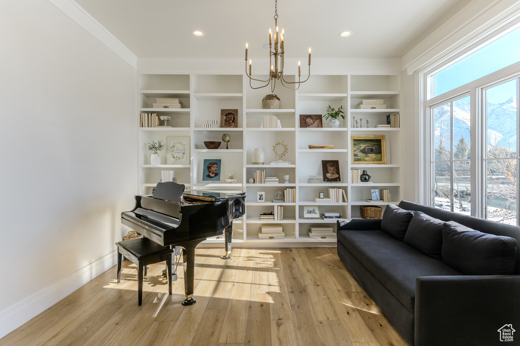 Sitting room featuring a notable chandelier, ornamental molding, and light hardwood / wood-style flooring