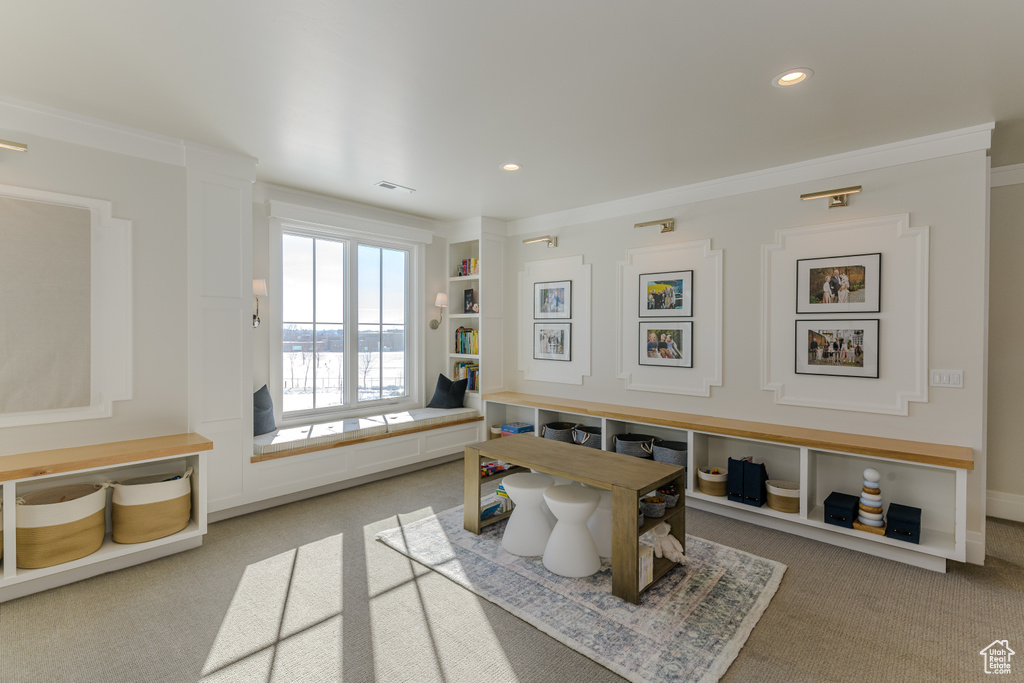 Interior space with crown molding and carpet flooring