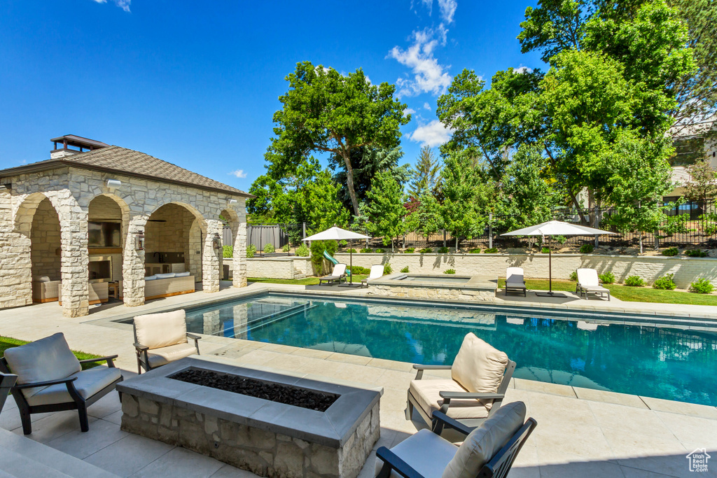 View of pool featuring a patio and a fire pit